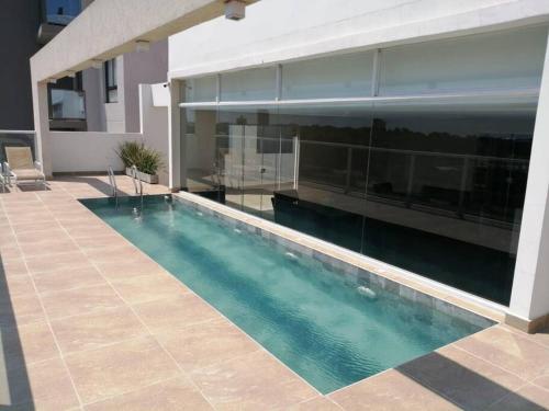 a swimming pool in front of a house at Hermoso conjunto residencial con piscina in Asunción