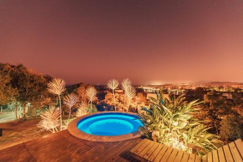 a swimming pool in the middle of a yard at night at Chalés e Bangalôs Ibiraquera in Praia do Rosa