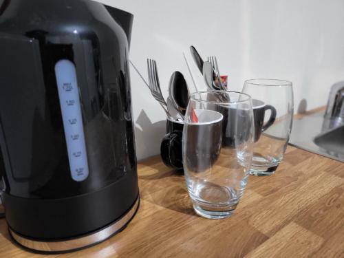 a coffee maker and two glasses on a counter at MM Sure Stay Accommodation - NG1 in Nottingham