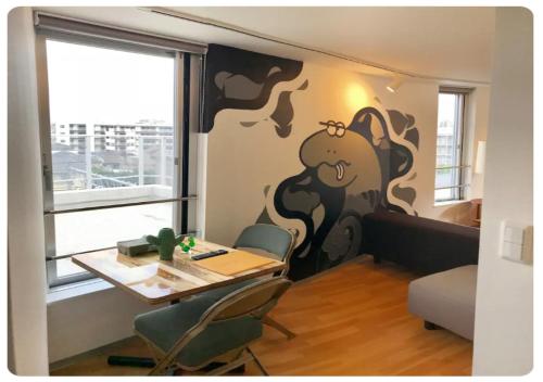 a dining room with a table and a cow mural on the wall at The Aoca Tokyo Sanno in Tokyo