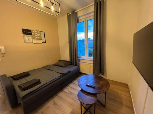 Cosy Apartment Merode في بروكسل: غرفة نوم بسرير وطاولة ونافذة