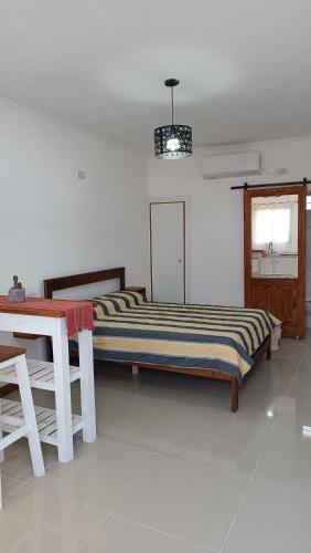Un dormitorio con una cama y una mesa y una ventana. en Caá Guazú, en Curuzú Cuatiá