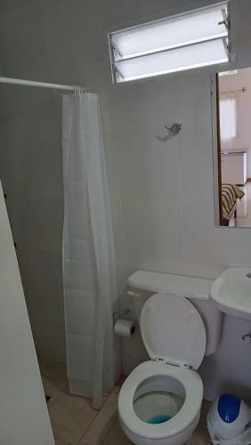 a white bathroom with a toilet and a sink at Caá Guazú in Curuzú Cuatiá