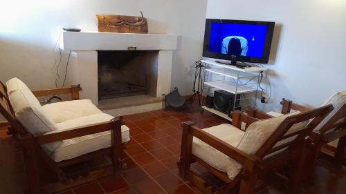 a living room with a tv and a fireplace at Bella Vista in Potrerillos