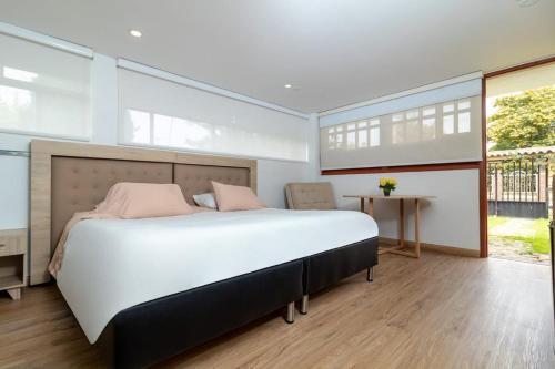 a bedroom with a large bed and a table at Hotel Gran Boutique Sabana in Chía