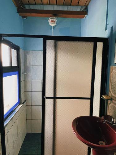 a bathroom with a sliding shower door and a sink at Casa hospedaje Puyo in Puyo