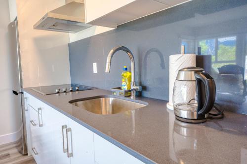 a kitchen counter with a sink and a mixer at Harrison Grand Motel in Harrison Hot Springs