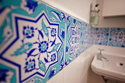 a bathroom with blue and white tiles on the wall at Cosy one bedroom flat in city center in Edinburgh