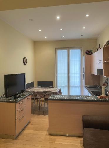 eine Küche und ein Esszimmer mit einem Tisch und einem TV in der Unterkunft Le fontane in Chiavari
