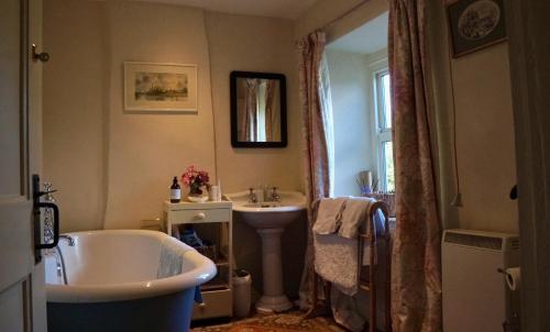 ein Badezimmer mit einer Badewanne und einem Waschbecken in der Unterkunft Orchard Cottage in Ripon