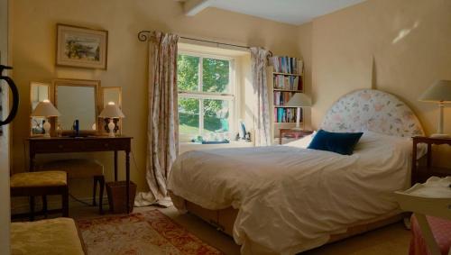a bedroom with a large bed and a window at Orchard Cottage in Ripon