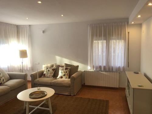 ein Wohnzimmer mit einem Sofa und einem Tisch in der Unterkunft Casa Veuràs Girona - Montilivi in Girona