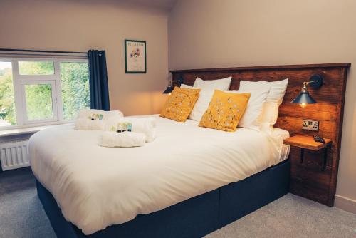 a bedroom with a large white bed with orange pillows at Reubens Congleton in Congleton
