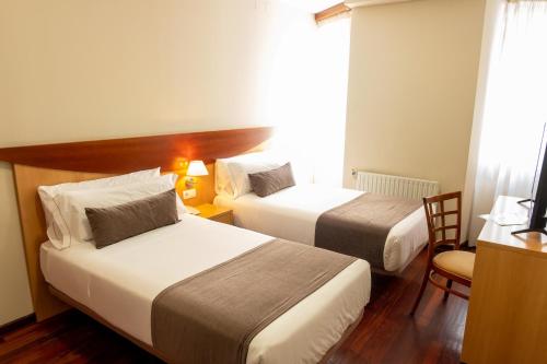 a hotel room with two beds and a window at Real Ferrol in Ferrol