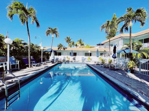 una piscina en un complejo con palmeras en Great Escape By Lowkl en Fort Lauderdale