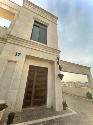 a large white building with a large wooden door at Contemporary Semi Villa Apartment with Private Entrance in Khalda in Amman