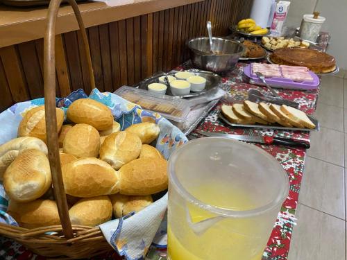 una mesa con una cesta de pan y un vaso de zumo de naranja en SOTAM HOTEL, en Fernandópolis