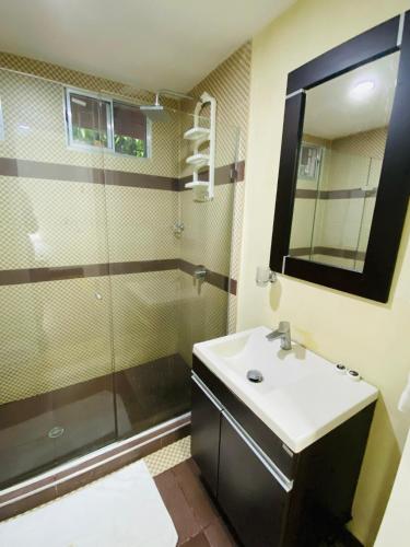 a bathroom with a shower and a sink and a mirror at Hotel Casa Colonial in Barranquilla