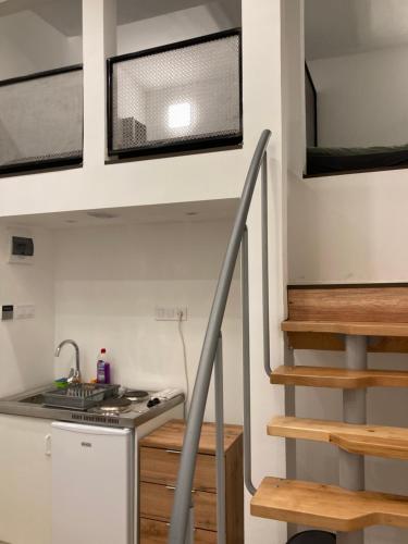 a tiny house with a kitchen and a staircase at Roland Apartment Downtown - Keleti in Budapest