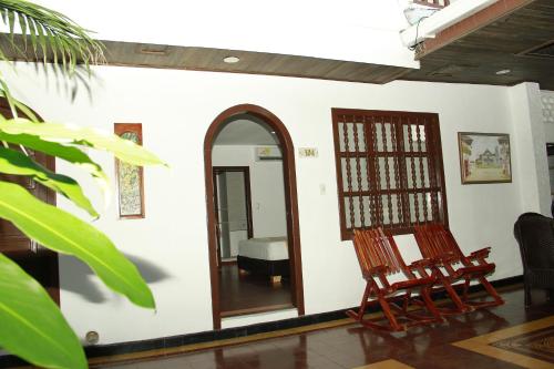 a room with two chairs and a mirror at Hotel Casa Colonial in Barranquilla
