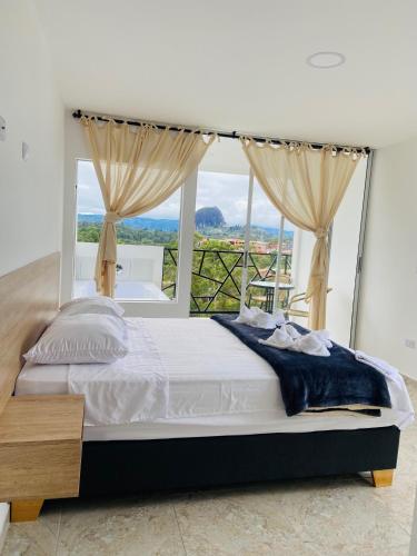 a bedroom with a bed and a large window at La Madriguera in Guatapé