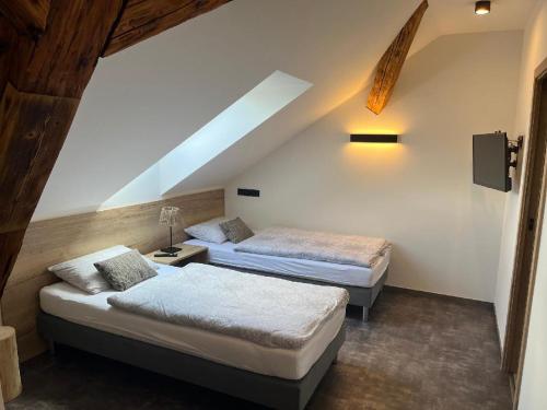 sypialnia z 2 łóżkami na poddaszu w obiekcie Penzion a Restaurace ZÁMECKÁ VRÁTNICA w mieście Vizovice