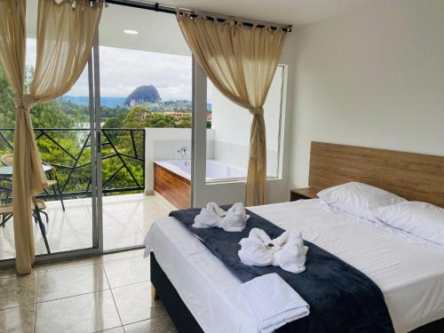a bedroom with a bed with towels on it at La Madriguera in Guatapé