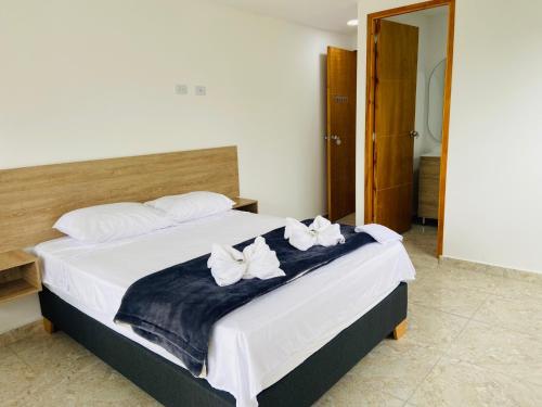 a bedroom with a bed with two white flowers on it at La Madriguera in Guatapé