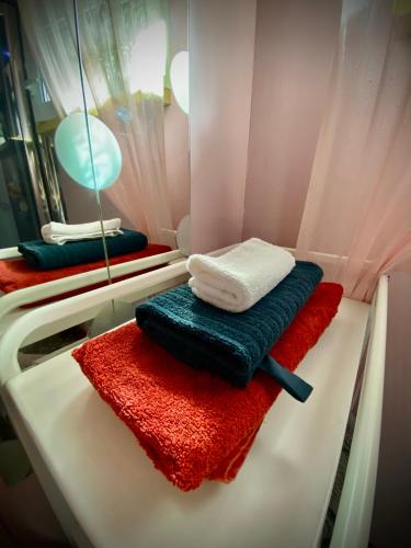 a bathroom with red and blue towels and a mirror at Amazing little house on an island with garden in Rīga