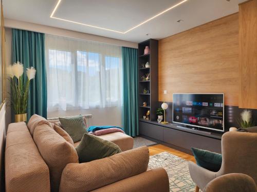 uma sala de estar com um sofá e uma televisão de ecrã plano em Modern Harmony em Kolašin