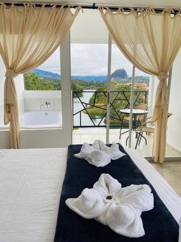 a bedroom with a bed with towels and a tub at La Madriguera in Guatapé