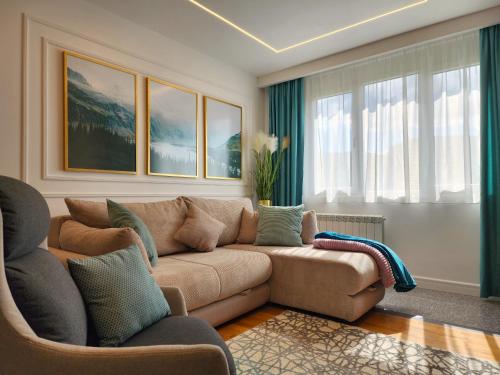 uma sala de estar com um sofá castanho e algumas janelas em Modern Harmony em Kolašin
