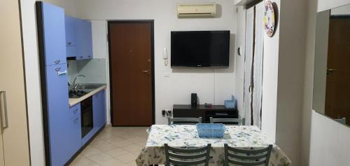 a room with a table and a kitchen with a television at Sweet Home in Chiaravalle