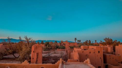 un groupe de bâtiments en briques rouges dans le désert dans l'établissement Gîte Ait lmaalam chez Ahmed, à Skoura