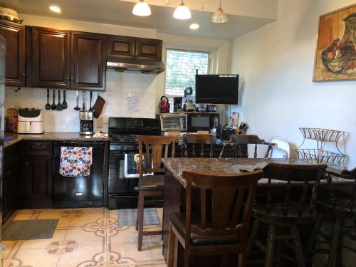 a kitchen with wooden cabinets and a bar with stools at Highland Park Pittsburgh in Pittsburgh