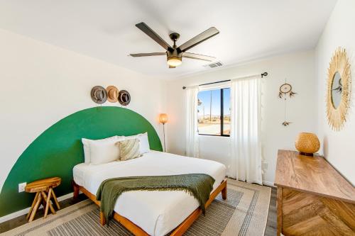 een slaapkamer met een groot bed met een groen hoofdeinde bij Yucca Dream in Yucca Valley