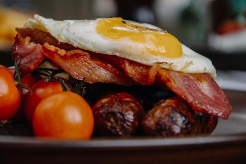 a breakfast of bacon eggs and tomatoes on a plate at The George Inn in Warminster