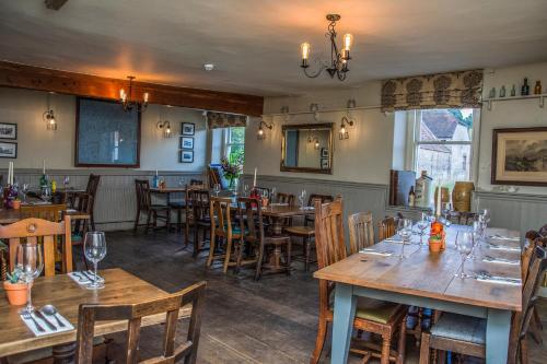 a restaurant with wooden tables and chairs in a room at The George Inn in Warminster