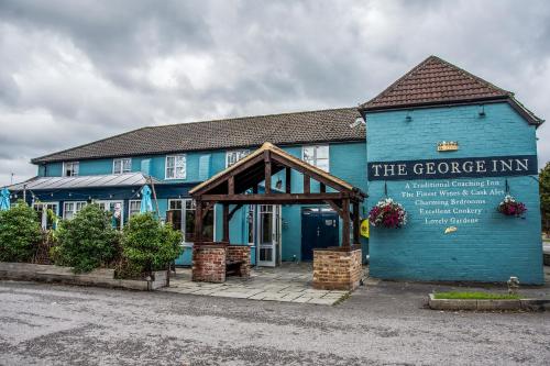a blue building with a sign in front of it at The George Inn in Warminster