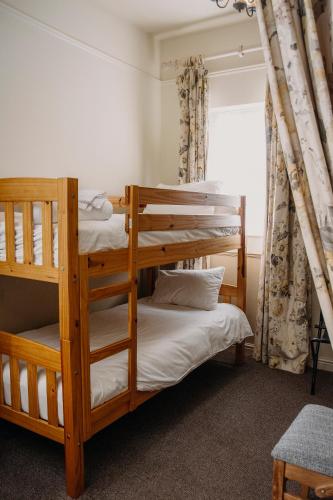 two bunk beds in a room with a window at The George Inn in Warminster