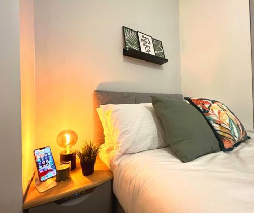 Un dormitorio con una cama y una mesa con un ordenador portátil. en SA Stays, en Wigan