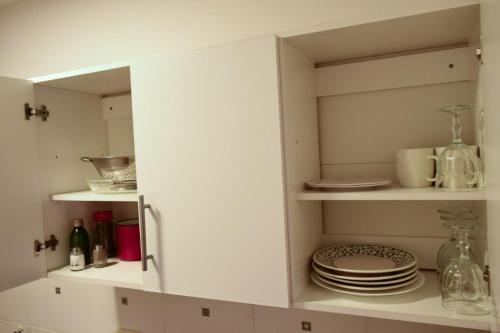 a kitchen cabinet with plates and dishes in it at El Luminoso 11 in La Plata