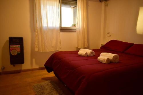 a bedroom with two red beds with towels on them at El Luminoso 11 in La Plata