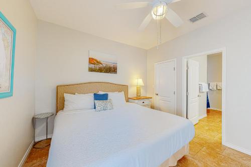 sypialnia z dużym białym łóżkiem z niebieskimi poduszkami w obiekcie Morgan Shores w mieście Port Aransas