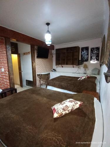a hotel room with two beds in a bedroom at Hotel Posada Spa Antigua Casa Hogar in Taxco de Alarcón