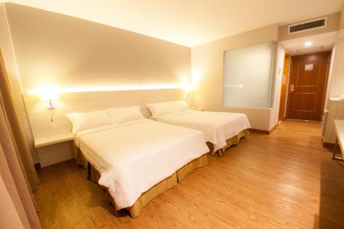 a hotel room with two beds and a mirror at Hotel Malaysia in George Town
