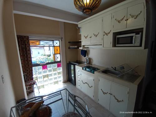 a small kitchen with a sink and a window at Hotel Posada Spa Antigua Casa Hogar in Taxco de Alarcón