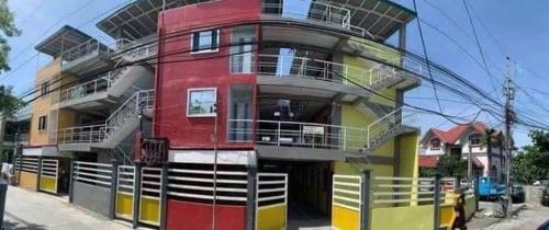 um edifício vermelho e amarelo no lado de uma rua em 4C’s Room Rental, Apartments, Hotel and Transient em Calapan