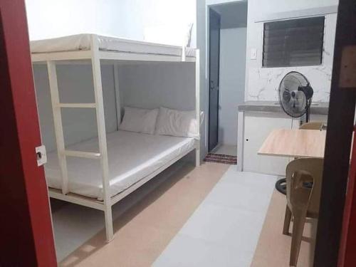 um beliche branco num quarto com uma secretária em 4C’s Room Rental, Apartments, Hotel and Transient em Calapan