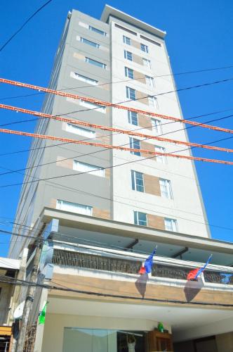 a tall white building with flags hanging from it at Cebu R Hotel Mabolo in Cebu City